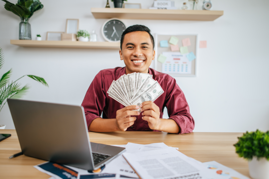 man holding cash in hand and smiling